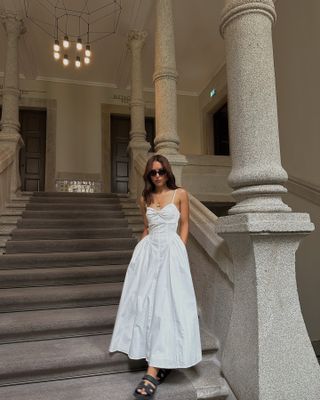 Woman in white fit-and-flare cotton dress.