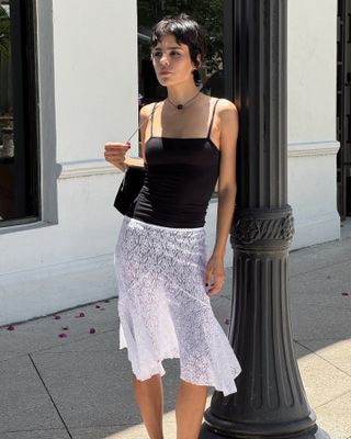 Woman in tank top and lace skirt.